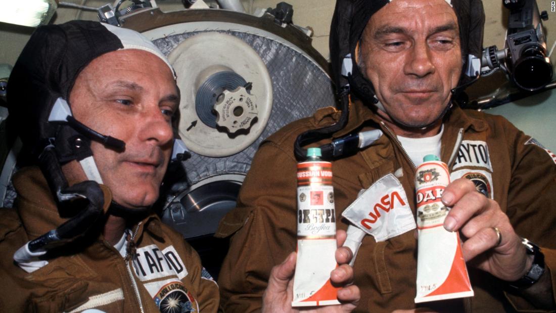 NASA Astronauts Thomas P. Stafford (left) and Donald K. &quot;Deke&quot; Slayton (right) hold containers of Soviet space food in the Soyuz Orbital Module during a nine-day joint US-USSR space mission in July 1975. The containers -- over which vodka labels have been pasted -- hold borscht (beet soup). This was the crews&#39; way of toasting each other.