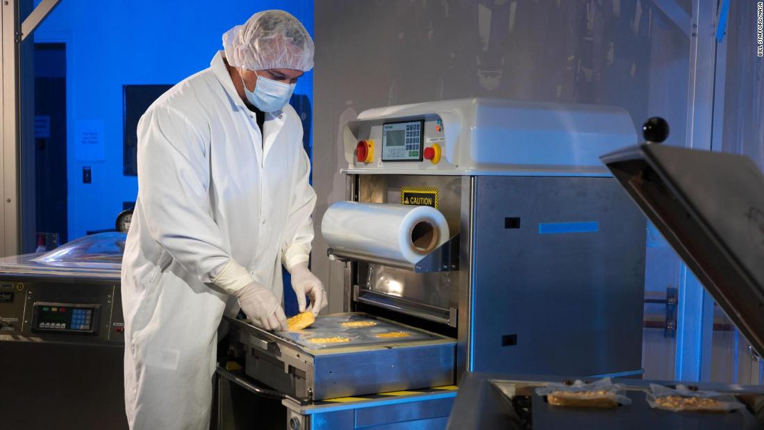 A food lab scientist packages food for spaceflight.