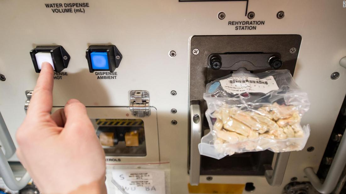 European Space Agency astronaut Samantha Cristoforetti prepares her lunch using the space food rehydrator aboard the International Space Station.