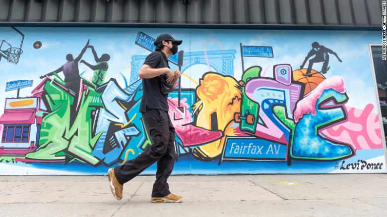 A man wearing a mask walks on Melrose Avenue on April 22, 2021 in Los Angeles, California