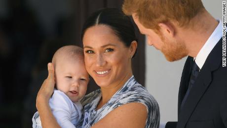 Meghan smiles while holding Archie alongside Harry during their trip to Cape Town, South Africa, on September 25, 2019.