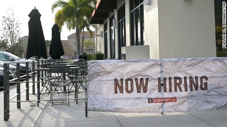 A Now Hiring banner sign is viewed outside a Chipotle restaurant during a new coronavirus pandemic, Tuesday, March 2, 2021, in Orlando, Fla. (Phelan M. Ebenhack via AP)