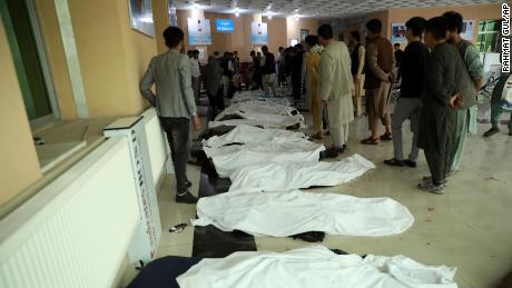 Afghan men try to identify the dead bodies at a hospital after a bomb explosion near a school west of Kabul, Afghanistan on Saturday. 