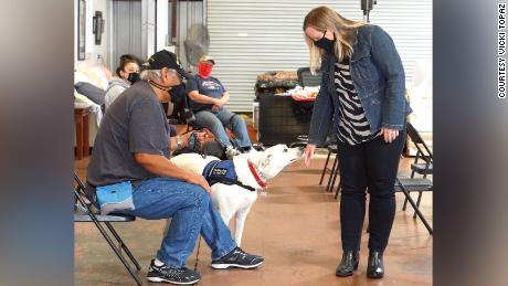 Author Shauna Springer gently extends the back of her hand as she visits with a service dog at Operation Freedom Paws.