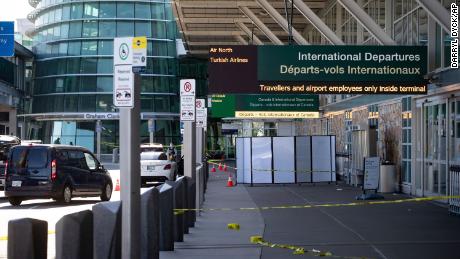 A Royal Canadian Mounted Police officer stands at the scene after a shooting outside the international departures terminal at Vancouver International Airport.