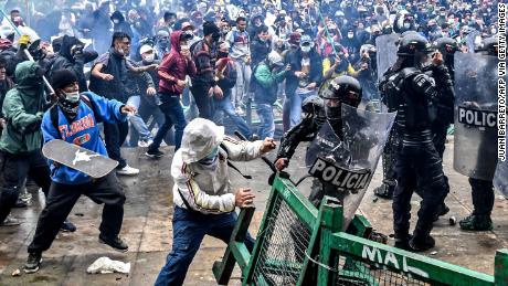 Demonstrators clash with riot police during a protest against a tax reform bill launched by Colombian President Ivan Duque, in Bogota, on April 28, 2021. 