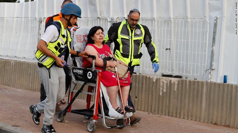 Israeli rescue teams evacuate a woman from a residential neighborhood in Ashkelon Tuesday after rockets were fired from the Gaza Strip towards Israel overnight amid spiralling violence. 