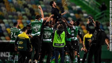 Players toss Sporting&#39;s head coach Ruben Amorim into the air after winning  the league title. 