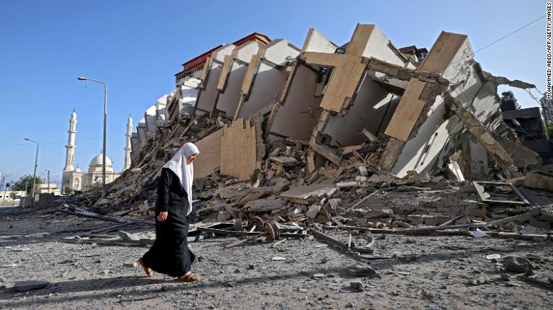 A Palestinian woman walks past a destroyed building in Gaza City early on Wednesday.