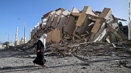 A Palestinian woman walks past a destroyed building in Gaza City early on Wednesday.