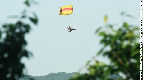 A staff member uses a powered parachute to search for an escaped leopard in the mountains near Hejia Village in the West Lake District of Hangzhou, capital of east China&#39;s Zhejiang Province, May 9, 2021.