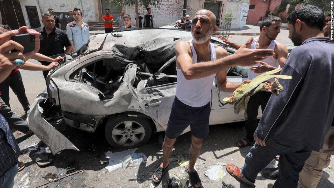 Palestinians inspect a vehicle destroyed by an Israeli airstrike after the bodies of its occupants were retrieved in Gaza City on May 12.