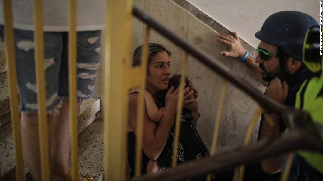 People sit on a staircase of a house in Ashkelon, Israel, as rockets are fired from Gaza on May 11.