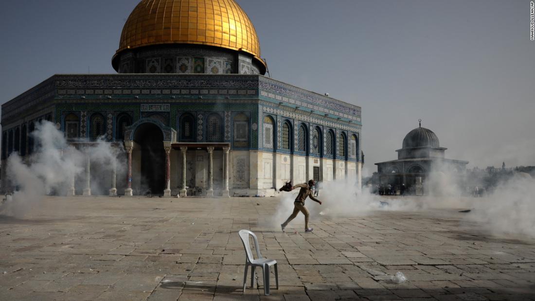 A Palestinian man runs from tear gas during clashes with Israeli security forces at the Aqsa Mosque compound in Jerusalem&#39;s Old City on May 10.