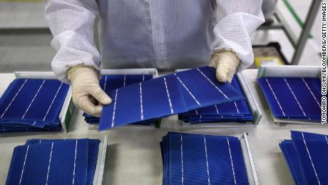 An employee performs a final inspection on solar cells on the production line at the Trina Solar Ltd. factory in Changzhou, Jiangsu Province, China in 2015. (Tomohiro Ohsumi/Bloomberg via Getty Images)
