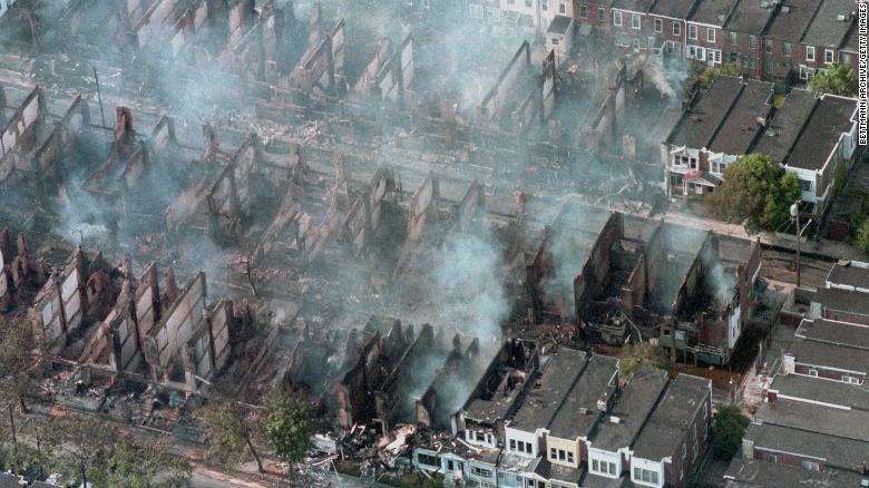 (Original Caption) Philadelphia, Pa.: Aerial view of smoke rising from smouldering rubble where some 60 homes were destroyed by fire after a shoot out and bombing at the back-to-nature terrorist group MOVE&quot;s house in West Philadelphia while police were attempting to force the group&#39;s eviction.