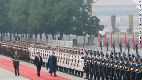 Afghanistan's President Hamid Karzai walks with China's President Xi Jinping as they review an honour guard during a welcoming ceremony at the Great Hall of the People in Beijing on September 27, 2013.