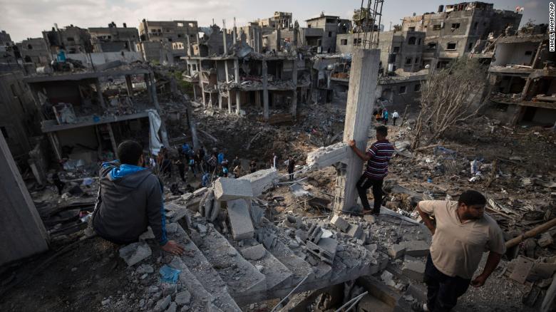 Palestinians inspect destroyed buildings following overnight Israeli airstrikes in the town of Beit Hanoun, Gaza, on Friday, May 14.