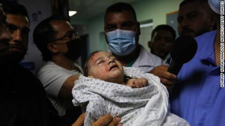 A baby is brought to Shifa Hospital in Gaza City for treatment on May 15, after being injured in an Israeli airstrike, which destroyed a 3-story house and killed 10 members of the child&#39;s family.