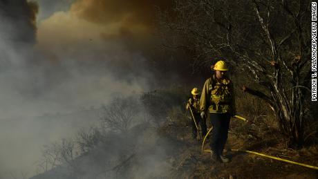 Los Angeles Fire Department firefighters wait for water pressure  to extinguish the flames from the Palisades fire in Topanga State Park, North West of Los Angeles on May 15, 2021. 