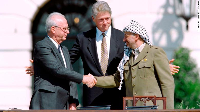 US President Bill Clinton watches as Israeli Prime Minister Yitzhak Rabin, left, and PLO leader Yasser Arafat shake hands on September 13, 1993 at the White House after signing the Oslo Accords.