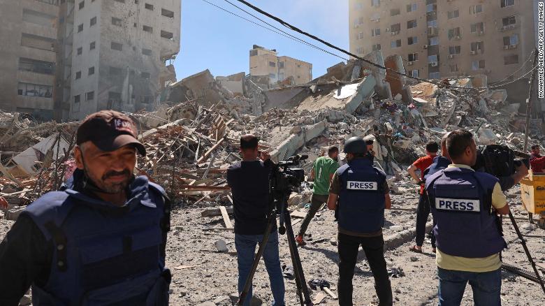 Journalists work near the destroyed Al-Jala&#39;a building, which housed international press offices, following an Israeli airstrike in Gaza on Saturday, May 15.