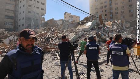 Journalists work near the destroyed Al-Jala&#39;a building, which housed international press offices, following an Israeli airstrike in Gaza on Saturday, May 15.