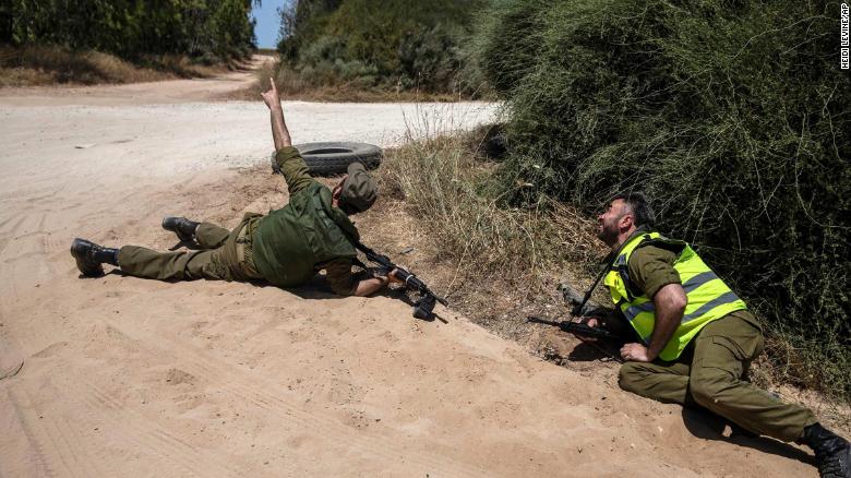 Israeli soldiers take cover near the Gaza border as a siren warns them about incoming rockets on May 17.