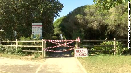 A beach closed sign in Tuncurry, Australia Tuesday after a surfer was killed by a shark.