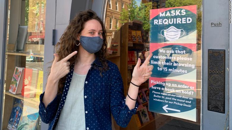 Colleen Callery, marketing director at Books are Magic in Brooklyn, stood next to the store&#39;s &quot;masks required sign,&quot; which will remain despite the CDC change in mask guidance last week.