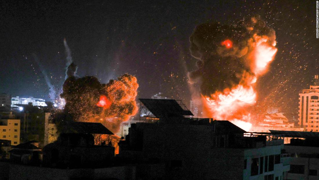 Explosions are seen over buildings in Gaza City as Israeli forces strike targets early on May 18.