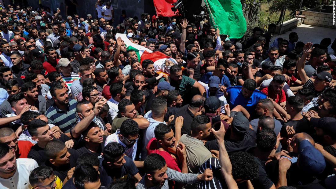 Palestinian mourners carry the body of Obaida Jawabreh, who was killed amid clashes with Israeli forces, during his funeral in the West Bank refugee camp of Al-Arrub on May 18.