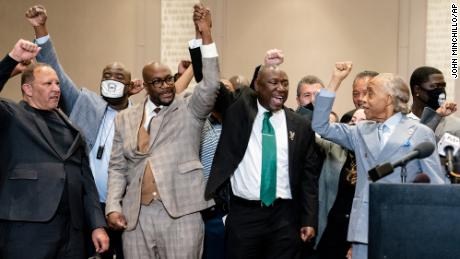 Ben Crump, flanked by Philonise Floyd, brother of George Floyd, center left, and the Rev. Al Sharpton, right, raise their hands in triumph after the murder conviction against former Minneapolis police Officer Derek Chauvin in the killing of George Floyd.