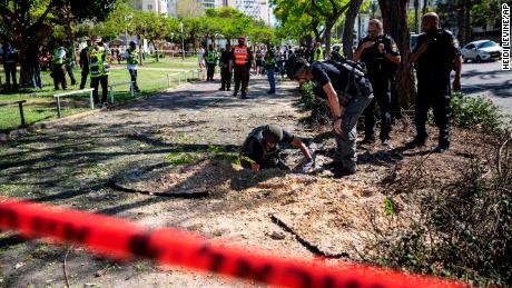 An Israeli bomb squad unit inspect the site where a rocket fired from Gaza hit a sidewalk in Ashdod, Israel, on Wednesday, May 19.