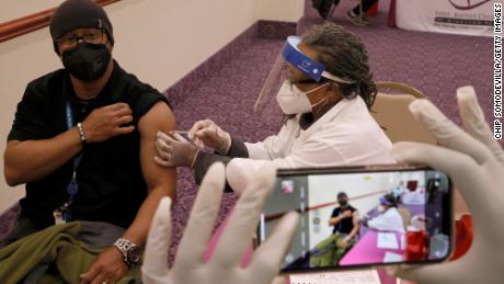 A person has his photograph taken as he receives the Moderna Covid-19 vaccine at First Baptist Church of Highland Park on March 18 in Landover, Maryland