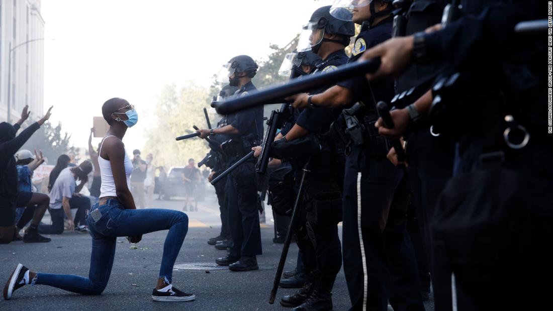 A protester takes a knee in front of police officers in San Jose, California, on May 29.