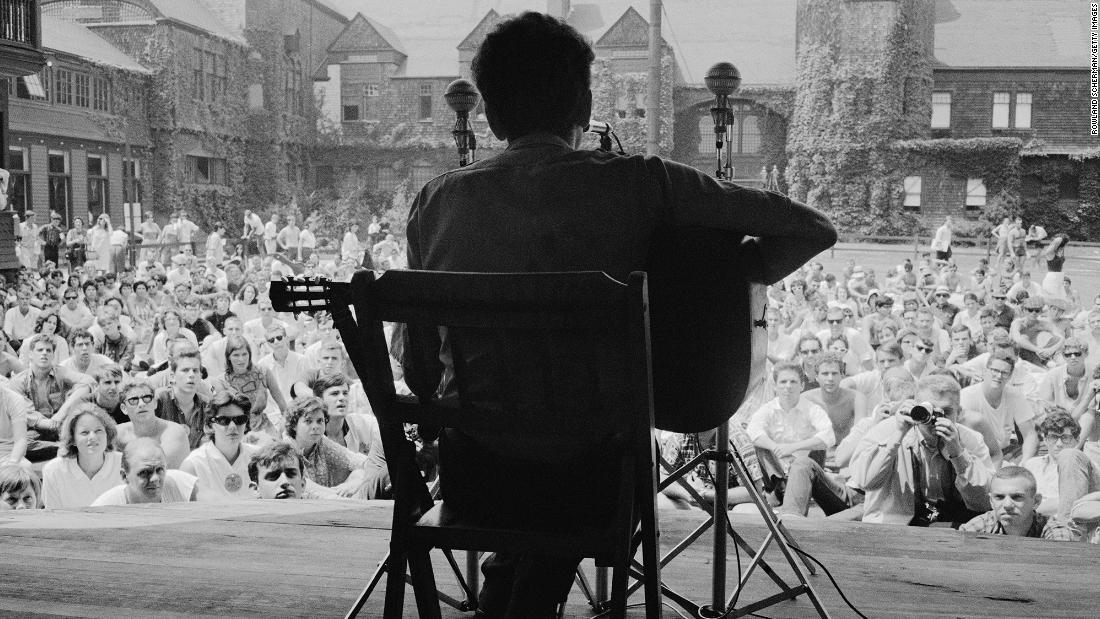 Dylan plays the guitar at the Newport Folk Festival in Newport, Rhode Island, in 1963. Dylan was known in his early career for playing the guitar and the harmonica, and for his distinctive vocal phrasing. 