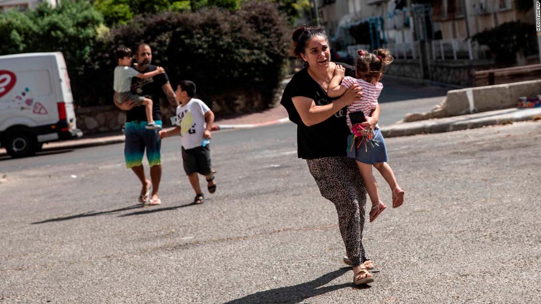 Lia Tal rushes with her children and partner to take shelter as a siren warns of incoming rockets in Ashdod, Israel, on May 20.