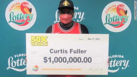 Curtis Fuller poses with an oversized check on May 17 after winning the 50X THE CASH scratch-off lottery game. He took home a lump-sum payment of $890,000.