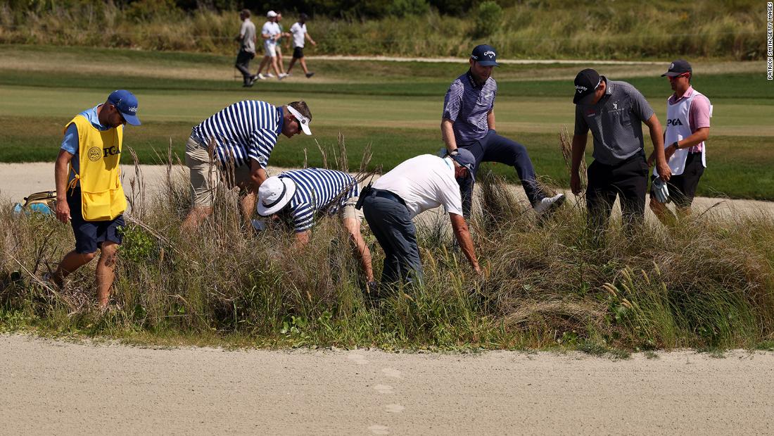 Branden Grace looks for his golf ball with Christiaan Bezuidenhout and caddies during the final round.