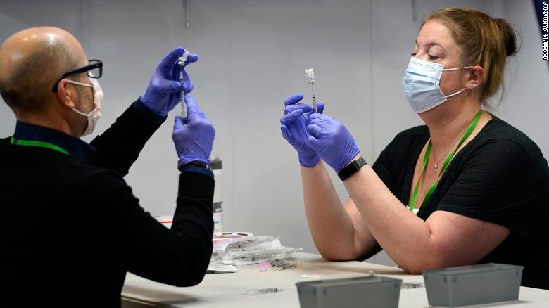 Pharmacy technicians fill syringes with Pfizer&#39;s Covid-19 vaccine on March 2 at the Portland Expo in Portland, Maine