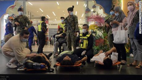 Rescue personnel help injured passengers at the KLCC station in Kuala Lumpur, Malaysia on May 24, 2021. 