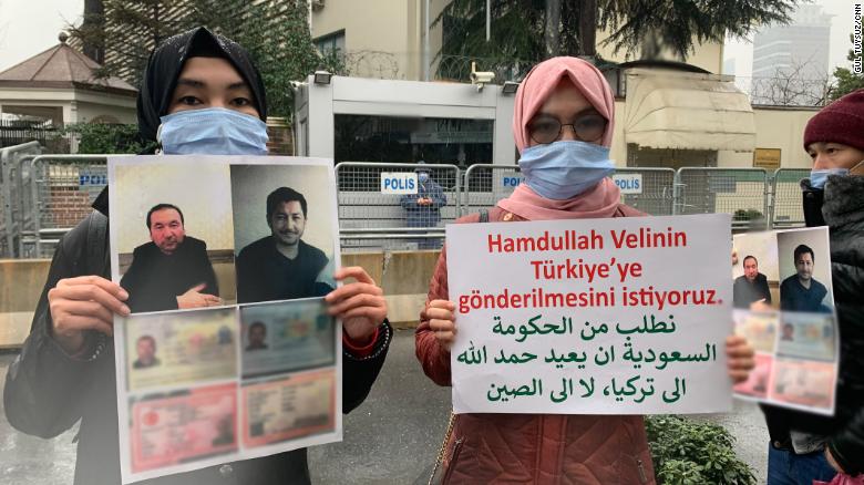 Nuriman Veli, second from left, and her sister protesting the disappearance of their father and his friend, pictured on the placard, outside Istanbul&#39;s Saudi consulate on February 12. CNN has blurred a portion of the photo to protect the men&#39;s personal details.