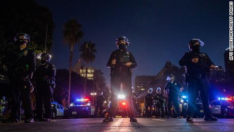 Police officers hold a line in front of Los Angeles City Hall during a protest demanding justice for George Floyd, Breonna Taylor and also in solidarity with Portland&#39;s protests in July 2020.