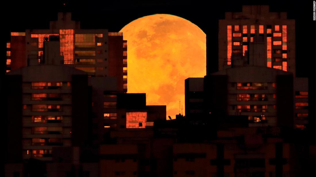 The moon is partially covered by buildings in Brasilia, Brazil, at the start of Wednesday&#39;s lunar eclipse.