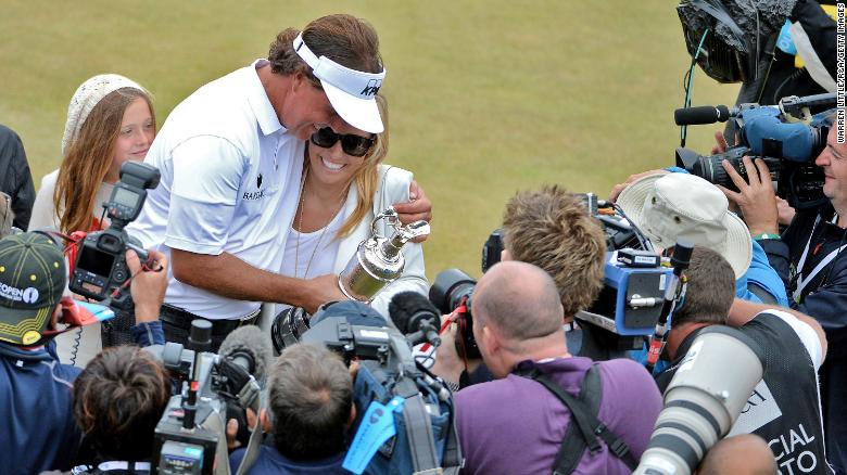 Mickelson holds the Claret Jug with wife Amy after winning the 142nd Open Championship at Muirfield in 2013.