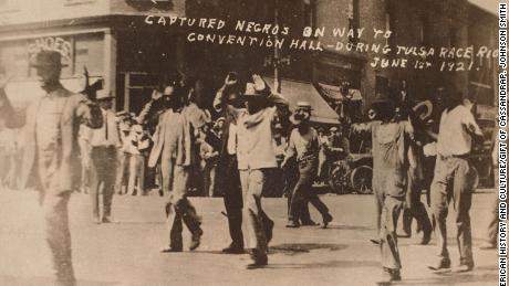 Men walk with their hands raised during the Tulsa massacre on June 1, 1921.