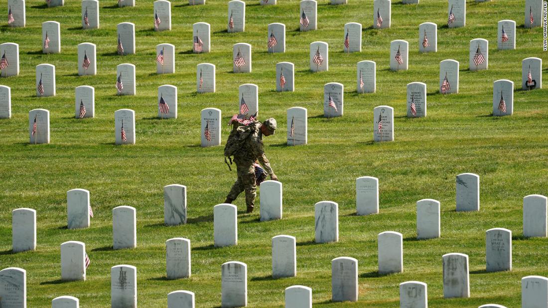 A US soldier places a flag as part of the Flags In ceremony at Arlington National Cemetery on Thursday, May 27. More than 1,000 service members placed flags in front of more than 260,000 headstones.