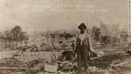 This photo provided by the Department of Special Collections, McFarlin Library, The University of Tulsa shows an unidentified man standing alone amid the ruins of what is described as his home in Tulsa, Okla., in the aftermath of the June, 1, 1921, Tulsa Race Massacre. (Department of Special Collections, McFarlin Library, The University of Tulsa via AP)