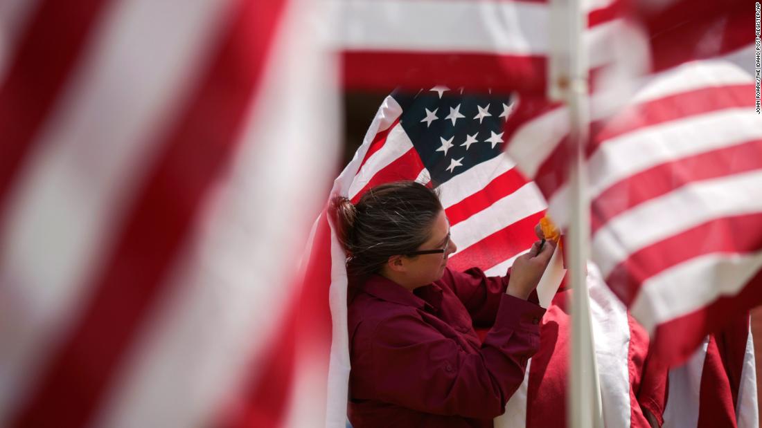 Jacqueline Blair hangs ribbons on flags Friday at the Field of Honor in Idaho Falls, Idaho. A thousand flags will be on display at the Russ Freeman Park through Memorial Day.